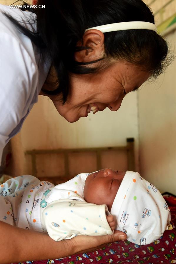  Doctor Yin Zuluan prepares for making a physical examination for a baby at a clinic in Guangsong Village, Dehong Dai and Jingpo Autonomous Prefecture, southwest China's Yunnan Province, Oct. 17, 2016. [Photo/Xinhua]