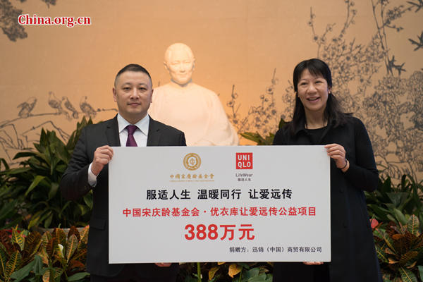 Pan Ning (L), CEO of Uniqlo's Greater China operations, hands over a check of 3.88 million yuan (US$653.4 thousand) to Tang Jiuhong, CSCLF's Funding Department chief, on Wednesday at the inauguration ceremony of the Uniqlo-CSCLF partnership in Beijing. [Photo by Chen Boyuan / China.org.cn]