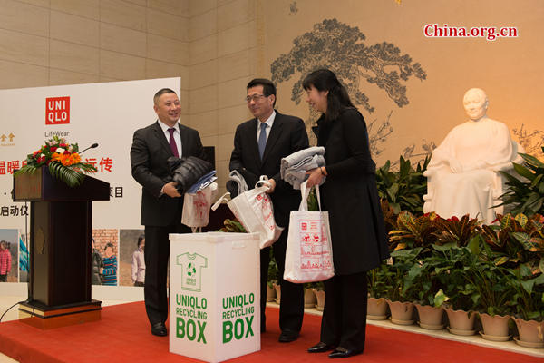 Pan Ning (L), CEO of Uniqlo's Greater China operations, Jing Dunquan, vice chairman of CSCLF (M) and Tang Jiuhong, CSCLF's Funding Department chief, takes the lead by donating their own clothes to be recycled by Uniqlo's charity plan on Wednesday at the inauguration ceremony of the Uniqlo-CSCLF partnership in Beijing. [Photo by Chen Boyuan / China.org.cn]
