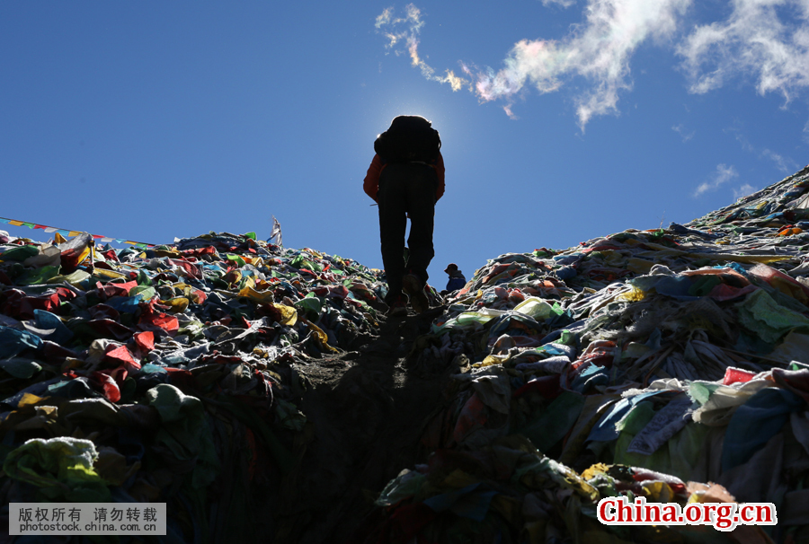 Kangjin Wangxue, 17, climbs over Duokelaya Pass in the morning. It is his first time participating in the garbage-cleaning activity. [Photo by Bai Jikai/China.com.cn]