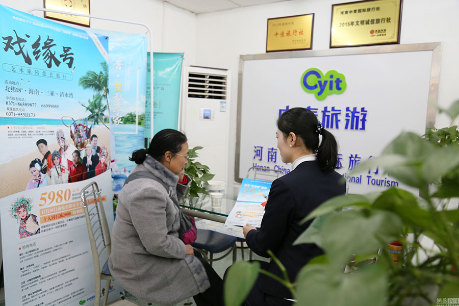 Ms. Li visits a travel agency, to get more information of the trip to Sanya, south China's Hainan Province. [Photo: 163.com]