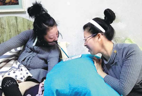 Typing on a tablet computer is hard work for Tian Xiaolu. [Photo/China Daily] 