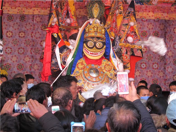 Tibetan Buddhists offer Khadaks and cash to the statue of the Pal Lhamo deity in Jokhang Temple during the Pal Lhamo Festival on Tuesday. [Photo by Palden Nyima/chinadaily.com.cn]