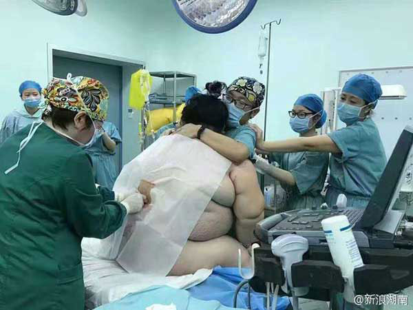 Medical staff members help the woman deliver the baby.[Photo: Sina Weibo]