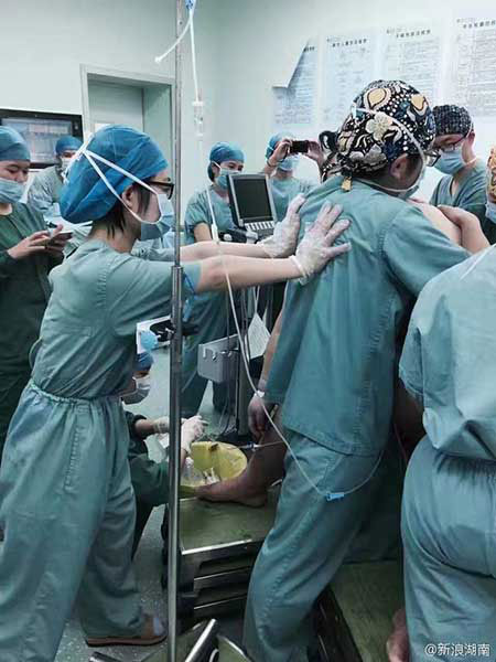 Medical staff members help the woman deliver the baby.[Photo: Sina Weibo]