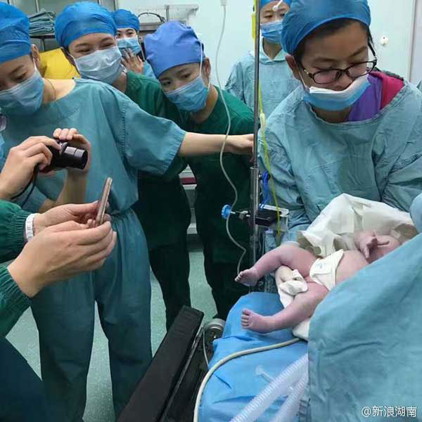 Medical staff members take photos for the newborn.[Photo: Sina Weibo] 