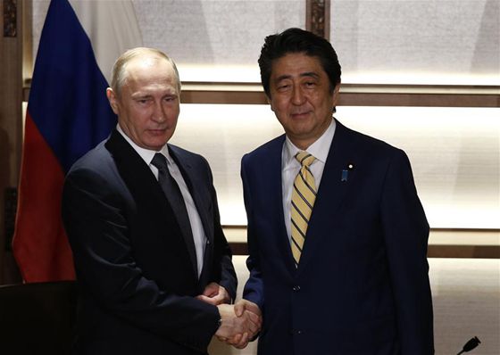 Russian President Vladimir Putin (L) shakes hands with Japanese Prime Minister Shinzo Abe prior to their meeting in Nagato, Yamaguchi prefecture, Japan, Dec. 15, 2016. [Photo/Xinhua]
