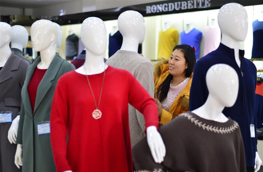 A customer shops for cashmere products at the 23rd China Qinghe International Cashmere and Fluff Products Fair in Qinghe County, north China's Hebei Province, Dec. 16, 2016. The 3 days fair, attracting more than 2,000 traders at home and abroad, opened on Friday in Qinghe, a traditional textile base. (Xinhua/Chen Lei)