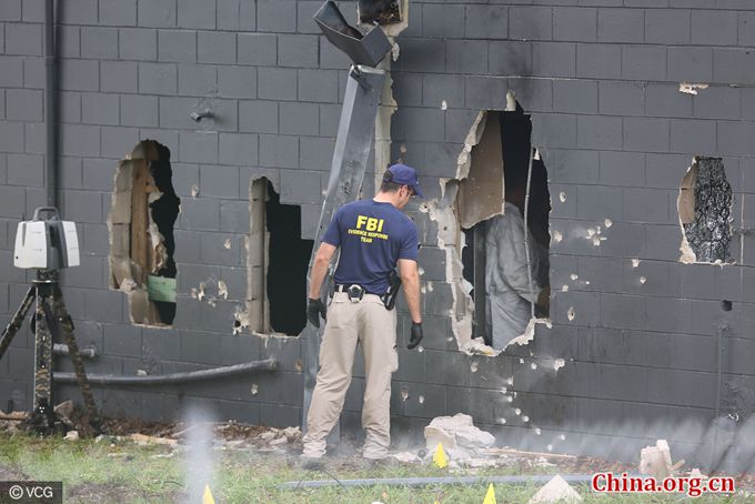 FBI agents investigate the damaged rear wall of the Pulse Nightclub where Omar Mateen allegedly killed at least 50 people on June 12, 2016 in Orlando, Florida. [Photo/China.org.cn]