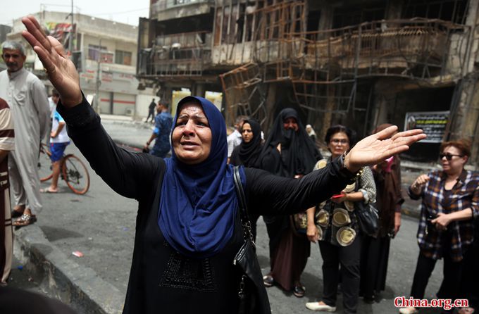 An Iraqi woman reacts on July 4, 2016 at the site of a suicide-bombing attack which took place a day earlier in Baghdad's Karrada neighbourhood. [Photo/China.org.cn]