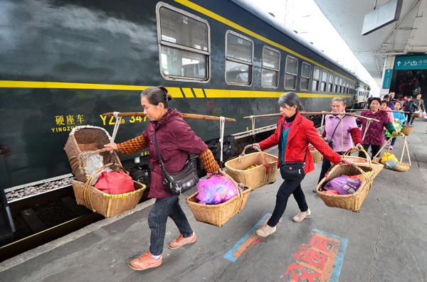 Vegetable farmers prepare to board a train in Chenzhou, Hunan province, late last month. [Photo/China Daily]