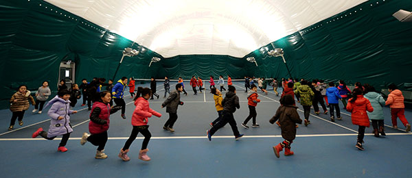 Students in a primary school in Shijiazhuang, capital of Hebei province, have their physical education class on Wednesday in a gym covered with an air cleaning system. [Photo/Xinhua]