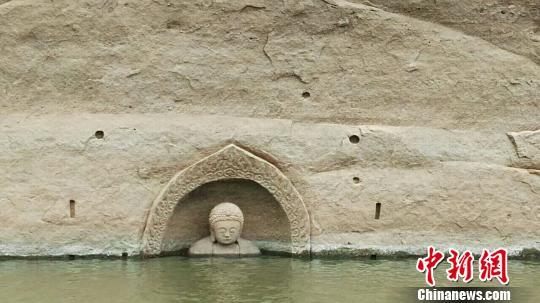 The head of a Buddha statue was spotted at Hongmen Reservoir in Nancheng County in the city of Fuzhou late last year when a hydropower gate renovation project lowered water levels in the reservoir by more than 10 meters. [Photo/Chinanews.com]
