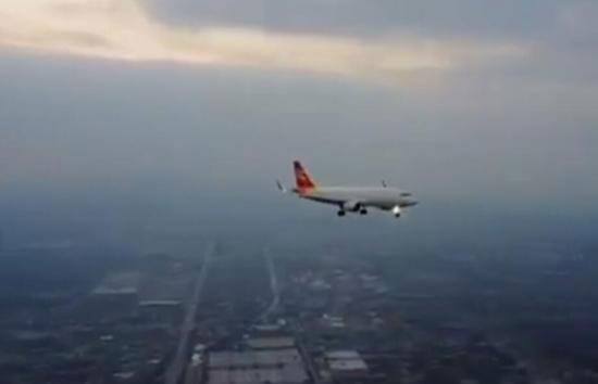  A screenshot of the video showing the landing of a passenger plane filmed by a drone only hundreds of meters away from the airliner. [Photo: China.com.cn]