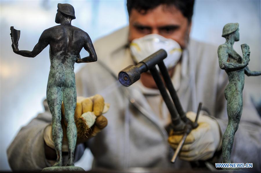 A worker colors the bronze statuette by using high heat during the production process of casting the bronze statuette for the 23rd annual Screen Actors Guild (SAG) Awards in Burbank, California, the United States, on Jan 17, 2017.