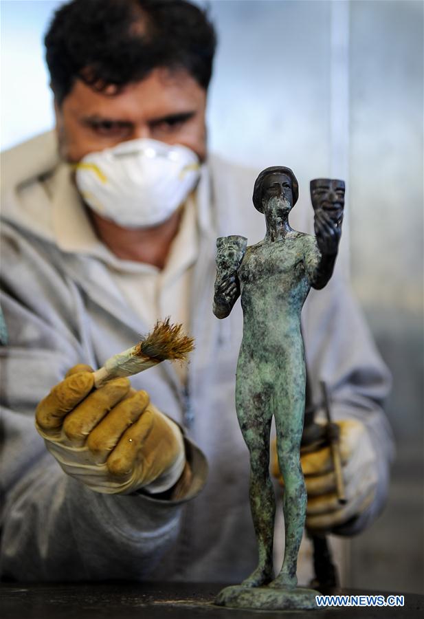 A worker colors the bronze statuette by using high heat during the production process of casting the bronze statuette for the 23rd annual Screen Actors Guild (SAG) Awards in Burbank, California, the United States, on Jan 17, 2017. 