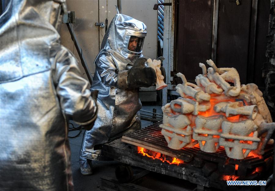 Workers prepare to take molds out of a furnace during the production process of casting the bronze statuette for the 23rd annual Screen Actors Guild (SAG) Awards in Burbank, California, the United States, on Jan 17, 2017. 