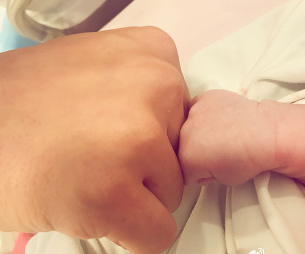 Chinese actor Huang Xiaoming posts a photo of his fist together with the fist of his newborn baby boy on Tuesday, January 17, 2017. [Photo/Weibo.com]