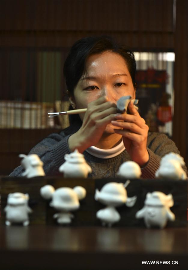 A style designer of Spring Festival dolls produces clay sculpture figures in Tianjin, north China, Jan. 18, 2017. As China's Spring Festival is coming, a comic team from Tianjin rolled out series comic works taking Spring Festival dolls as protagonists for the production of wechat expression package, clay sculpture and relevant derivatives. [Photo/Xinhua]