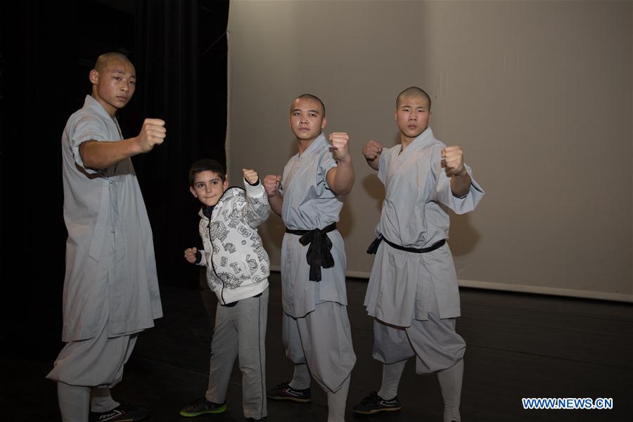 Shaolin monks and a local kid pose for photos after the Chinese martial arts performance in Tel Aviv, Israel, Jan. 18, 2017. The performance was part of the celebrations for the 25th anniversary of the establishment of the diplomatic relations between China and Israel. [Photo/Xinhua]