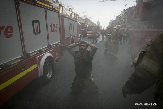 An Iranian firefighter mourns beside a commercial building in downtown Tehran, Iran, on Jan. 19, 2017. [Photo/Xinhua]