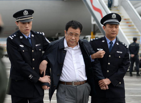 Chinese police escorting Li Huabo (C), second of the list of China's '100 most wanted economic fugitives' after he arrived at Beijing Capital International Airport. May 9, 2015. [Photo / Xinhua]