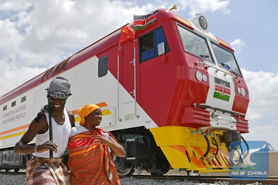 Kenyans sing and dance beside one of the first batch of locomotives for the Mombasa-Nairobi standard gauge railway in Mombasa, Kenya, on Jan. 11, 2017. [Photo/Xinhua]