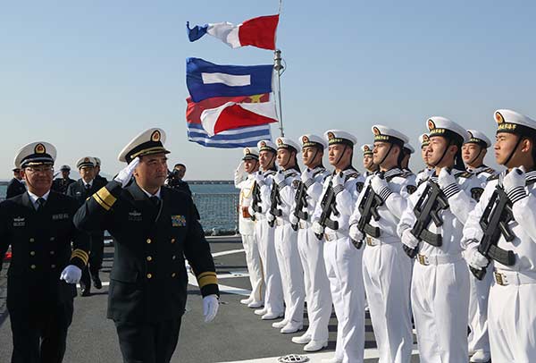 Rear Admiral Zhang Wendan, commander of the North Sea Fleet, views the guard of honor on the CNS Xining in Qingdao, Shandong province, on Sunday. [Photo/China Daily]