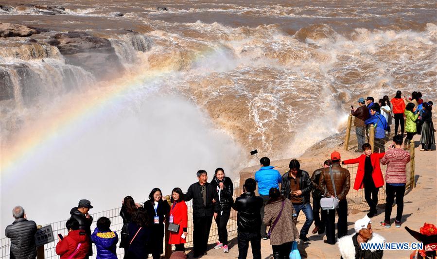 Visitors view the Hukou Waterfall beside the Yellow River in Jixian County, north China&apos;s Shanxi province, Feb. 17, 2017. As temperature rises and ice on the Yellow River melts, water at Hukou Waterfall surges, which attracted lots of tourists. (Xinhua/Lyu Guiming) 