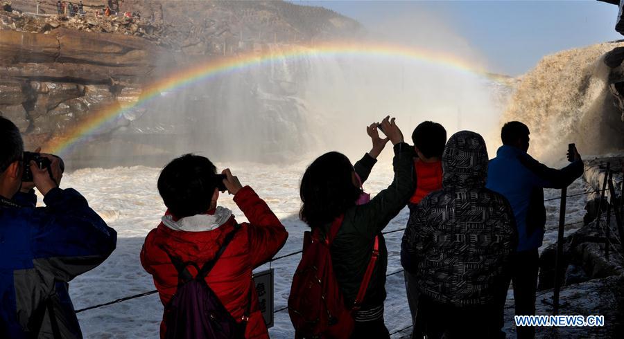Visitors view the Hukou Waterfall beside the Yellow River in Jixian County, north China&apos;s Shanxi province, Feb. 17, 2017. As temperature rises and ice on the Yellow River melts, water at Hukou Waterfall surges, which attracted lots of tourists. (Xinhua/Lyu Guiming)