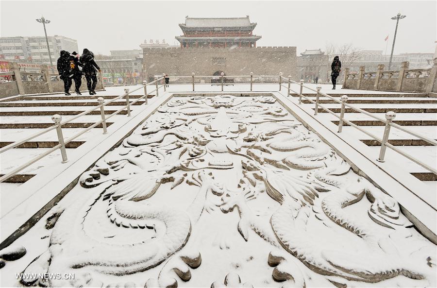 People walk in snow in Zhangjiakou City, north China's Hebei Province, Feb. 21, 2017. A cold front brought snowfall to many parts of north China. [Photo/Xinhua]