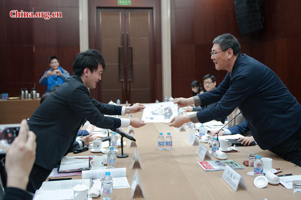 Masayuki Inoue (L) receives a souvenir from the organizer of the essay contest on Feb. 22, 2017 in Beijing. [Photo by Chen Boyuan / China.org.cn] 