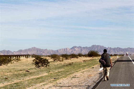 A migrant walks on a highway in the Mexican state of Sonora, on Feb. 10, 2017. [Photo/Xinhua]