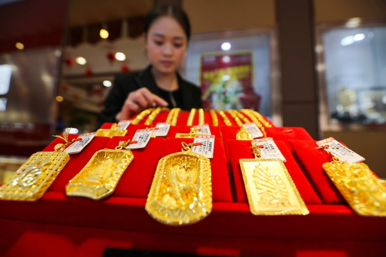 A staff member at a gold store arranges jewelry in Lianyungang, Jiangsu province, on Nov 6, 2016. [Photo/China Daily]