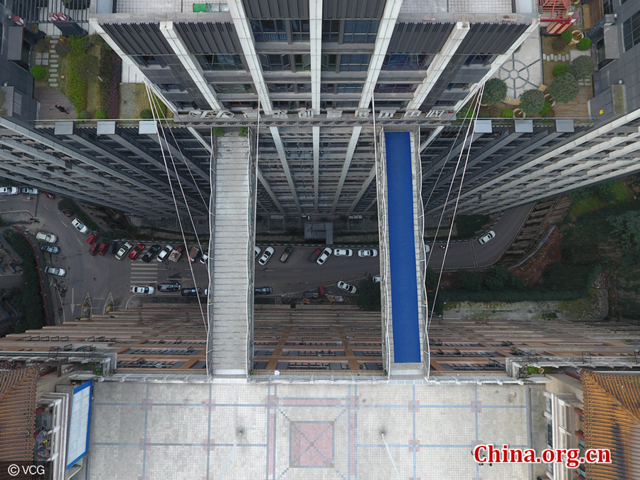 Two footbridges, each being 23 meters long and four meters wide, are in parallel connecting two high buildings in downtown Chongqing. The photo was taken on March 16, 2017. [Photo/China.org.cn]