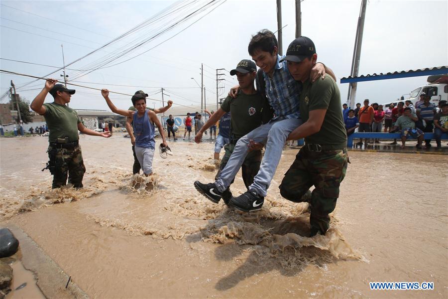 Members of the security forces help a person after the overflow of the Rimac river, in a sector of Huachipa, Lima, Peru, on March 16, 2017. The strong rains caused by the coastal El Nino phenomenon affected Lima since Wednesday afternoon. Flooding has claimed at least 62 lives as of Thursday and left countless people homeless, with 750 towns in 13 regions declared to be in a state of emergency. (Xinhua/Juan Carlos Guzman/ANDINA) 