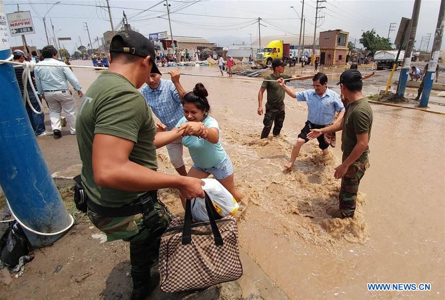A member of the security forces helps residents after the overflow of the Rimac river, in a sector of Huachipa, Lima, Peru, on March 16, 2017. The strong rains caused by the coastal El Nino phenomenon affected Lima since Wednesday afternoon. Flooding has claimed at least 62 lives as of Thursday and left countless people homeless, with 750 towns in 13 regions declared to be in a state of emergency. (Xinhua/Juan Carlos Guzman/ANDINA) 