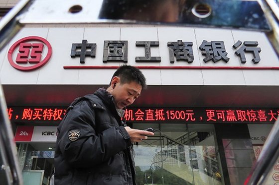 A man passes by a branch of Industrial and Commercial Bank of China Ltd, the nation's largest lender, in Shanghai on March 7, 2014. [Photo/China Daily]