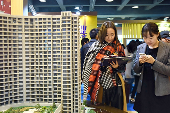 Prospective home buyers check out new property prices at a sales event in Hangzhou, Zhejiang province, East China, on Dec 17, 2016. [Photo/China Daily] 