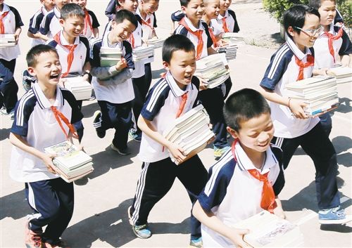 Students from a primary school in An County in southeast China's Jiangxi Province hold books donated to them by China's Publishers Association on April 14, 2017.[Photo: people.com.cn]