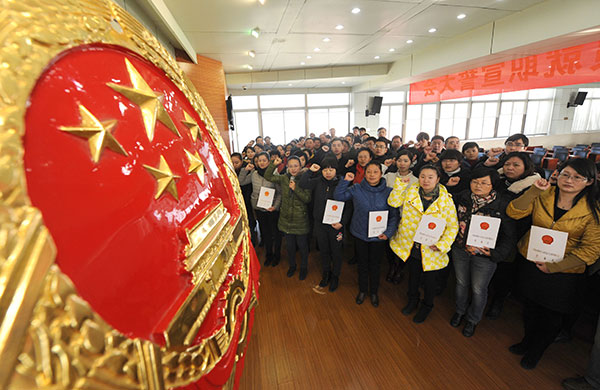 Jurors are sworn in as they face the Chinese national emblem in Hefei, Anhui province. [Photo by Xie Chen/China Daily]