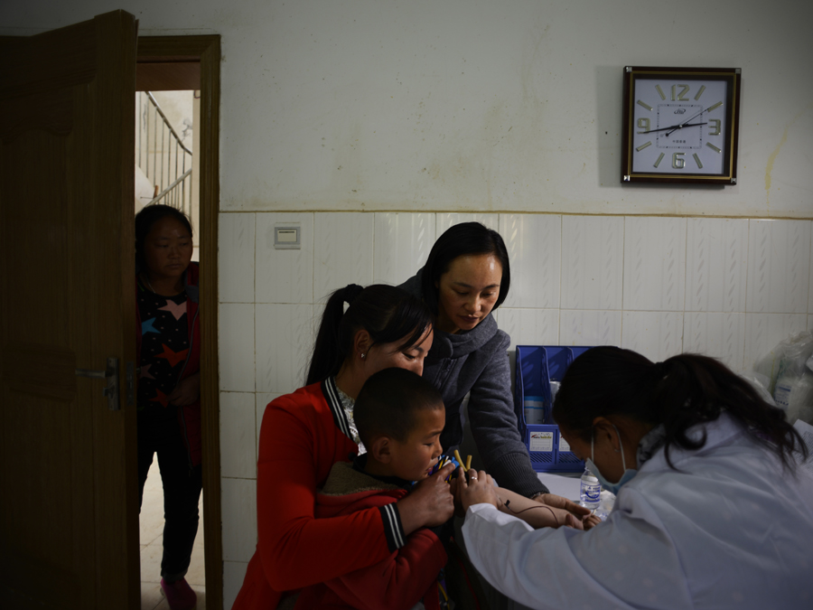 Doctor Ma Li takes a five-year-old boy, Li Jiarui, to a county hospital to receive a health check. [Photo by Pan Songgang/China.org.cn]
