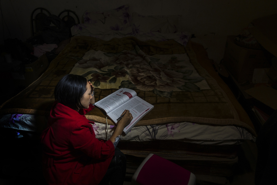 Doctor Ma Li reads medical books in her room by faint lamplight at night. [Photo by Pan Songgang/China.org.cn] 