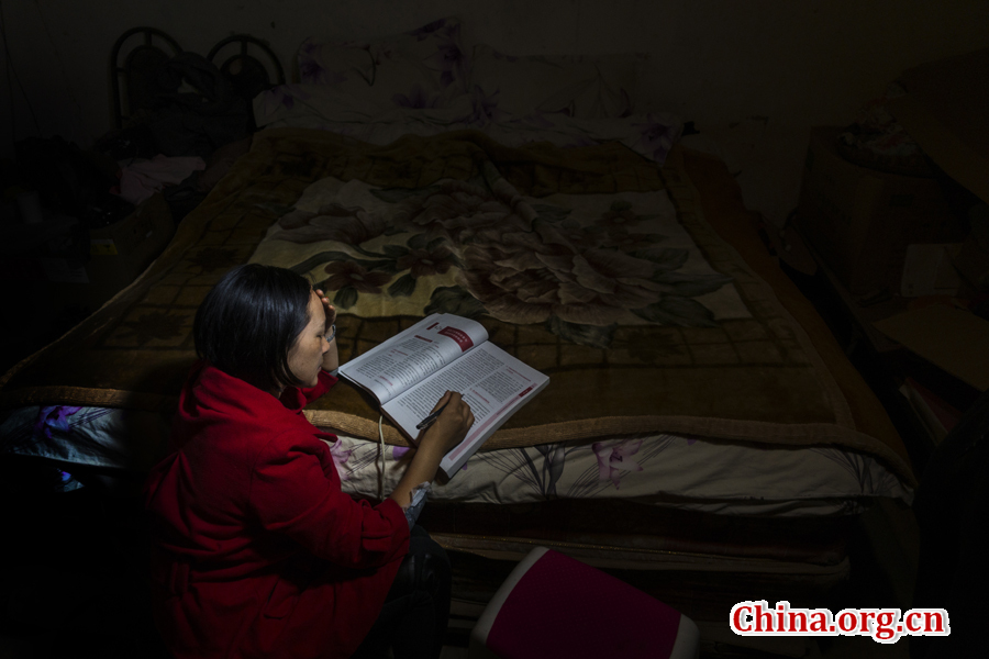 Doctor Ma Li reads medical books in her room by faint lamplight at night. [Photo by Pan Songgang/China.org.cn] 