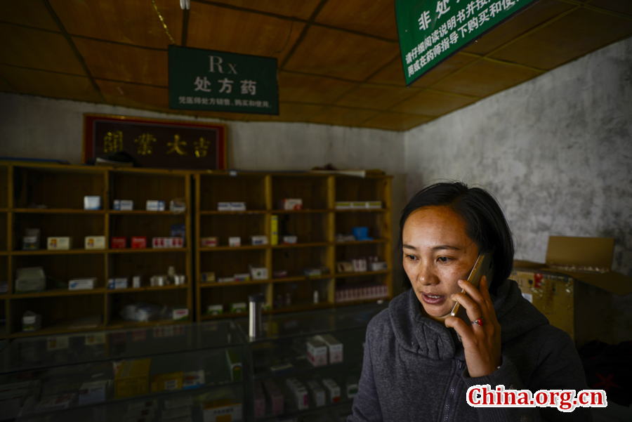 Doctor Ma Li receives an emergency call from a villager. The signal is bad in the mountains, but Ma Li carries the mobile phone with her whenever and wherever possible so as not to miss any emergency call. [Photo by Pan Songgang/China.org.cn] 