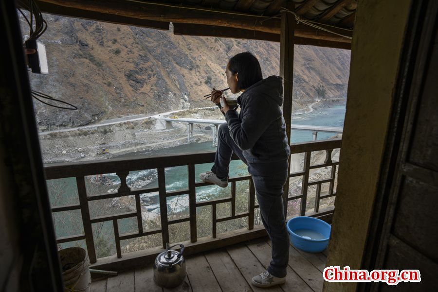 Doctor Ma Li takes a break from work. She enjoys the beautiful mountain scenery while having a simple meal. [Photo by Pan Songgang/China.org.cn] 