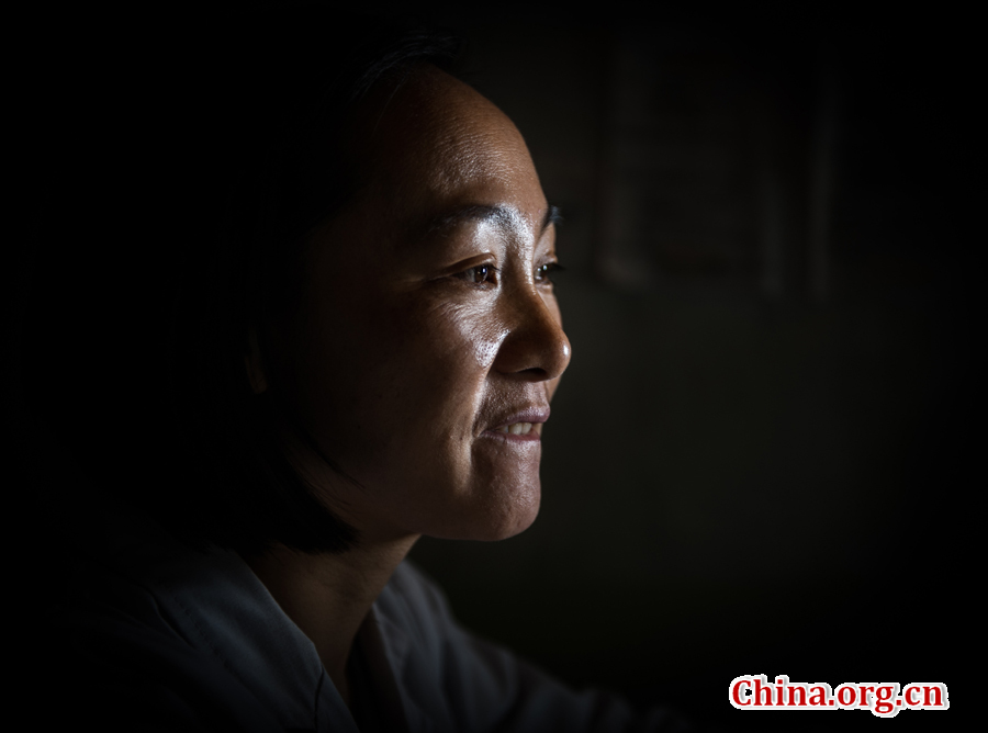 Thirty-five-year-old Ma Li studied the wrinkles in her face. Despite the tough environment, she is still passionate about her job as a doctor in the remote mountain village. [Photo by Pan Songgang/China.org.cn] 