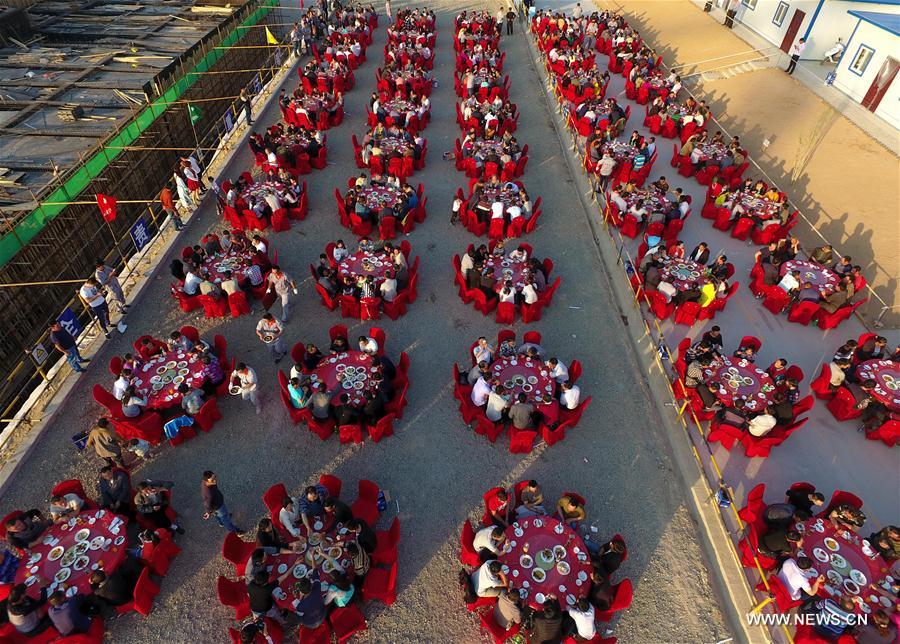 Migrant workers have a meal at a construction site in Yuncheng city, north China&apos;s Shanxi Province, April 28, 2017. Over 600 migrant workers from southwest Sichuan province gathered together to celebrate the upcoming Labor Day holiday.(Xinhua/Cao Yang) 
