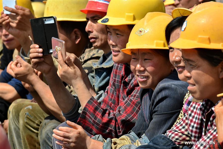 Migrant workers watch a folk show at a construction site in Yuncheng city, north China&apos;s Shanxi Province, April 28, 2017. Over 600 migrant workers from southwest Sichuan province gathered together to celebrate the upcoming Labor Day holiday. (Xinhua/Cao Yang) 