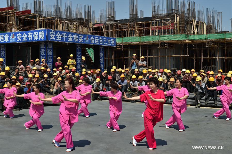 Migrant workers watch a folk show at a construction site in Yuncheng city, north China&apos;s Shanxi Province, April 28, 2017. Over 600 migrant workers from southwest Sichuan province gathered together to celebrate the upcoming Labor Day holiday.(Xinhua/Cao Yang) 